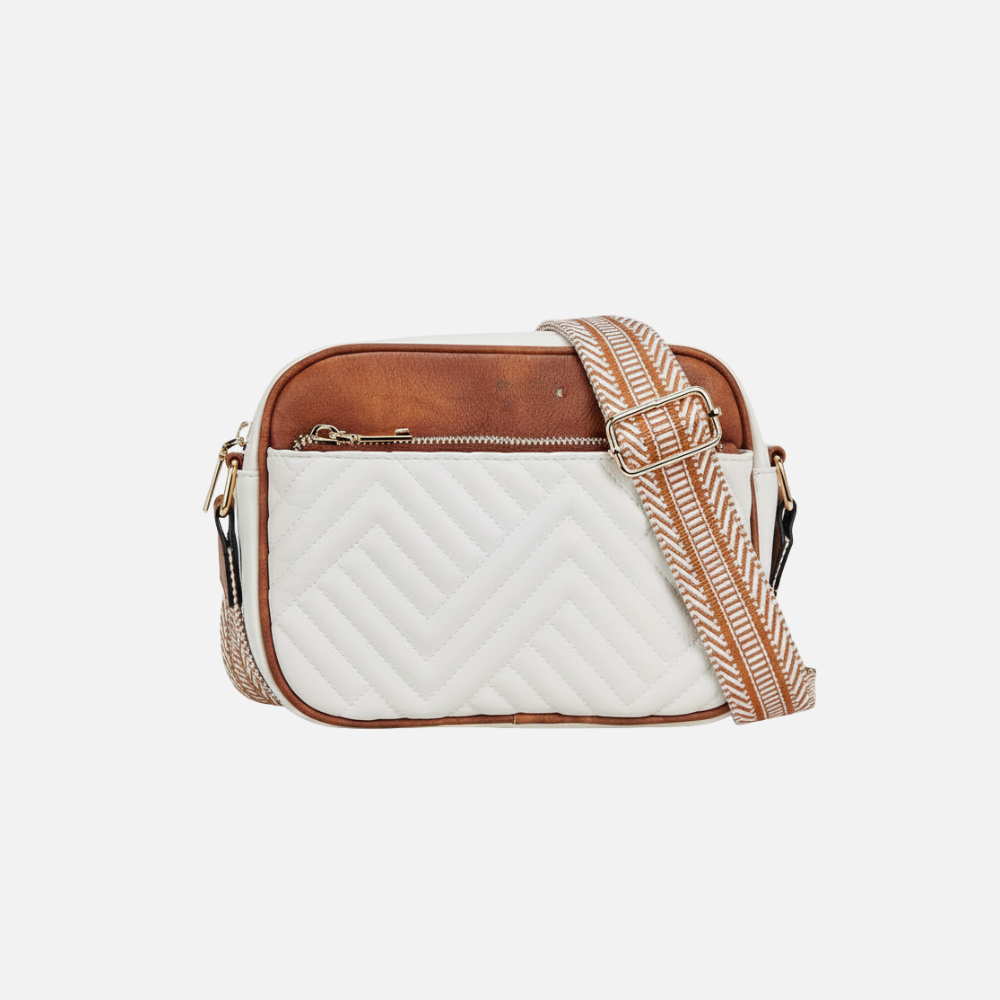 White quilted crossbody bag with brown accents and a patterned strap on a white background